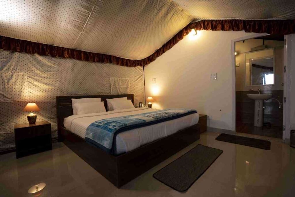 Luxury tent interior with a large bed and attached bathroom